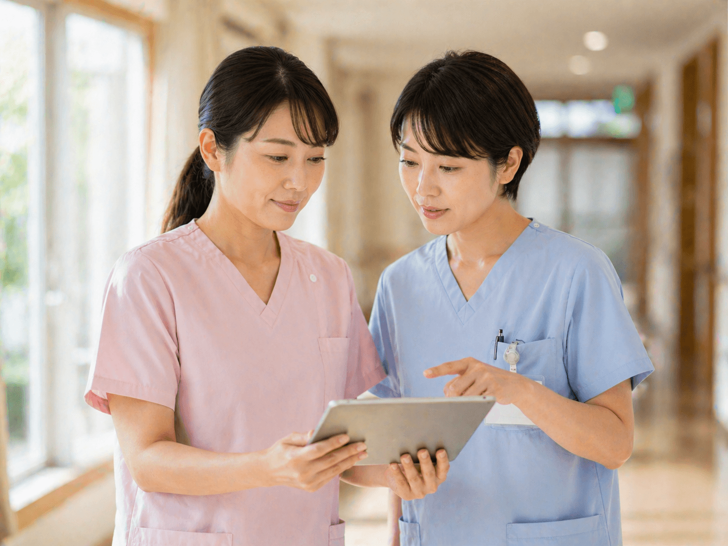 介護スタッフと看護師がタブレットで情報を共有する様子