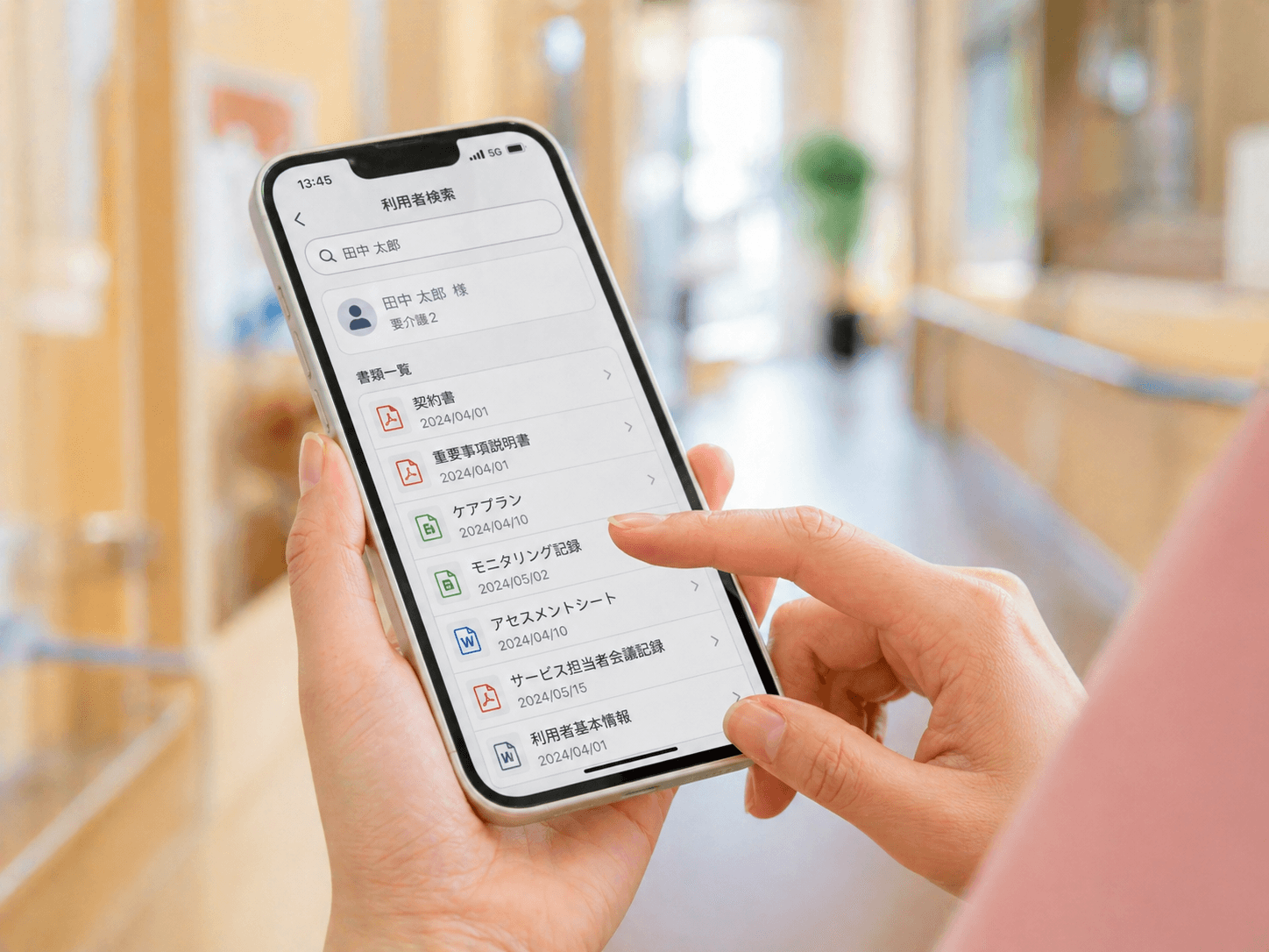 スマホで利用者の書類リストを瞬時に開く介護スタッフ